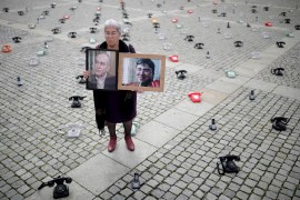 Fadwa Mahmoud holds portraits of her son and husband, who disappeared in 2012, as around 300 landline telephones placed by Syrian families stand at the Bebelplatz as a call to governments to do more to seek information about detained people in Syria, in Berlin, Germany August 28, 2021. REUTERS/Hannibal Hanschke TPX IMAGES OF THE DAY