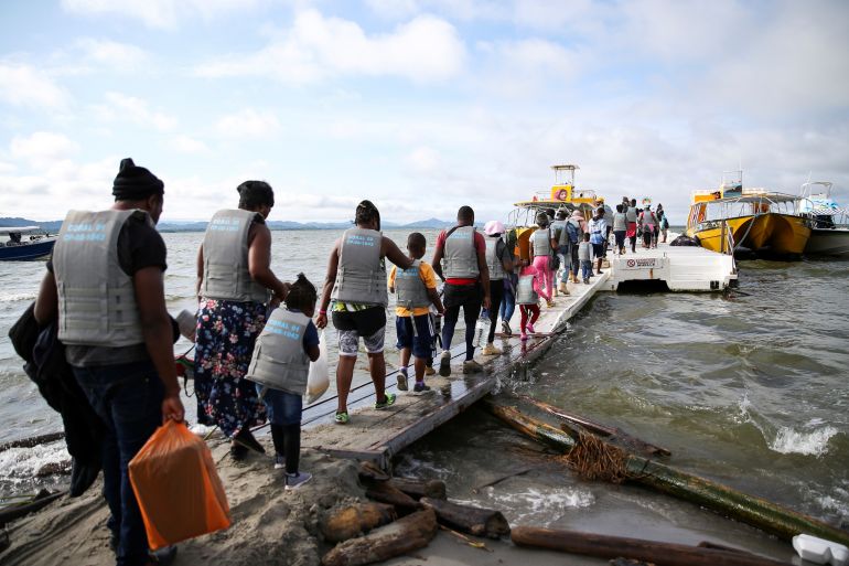 Migrants and refugees board a boat in Necocli, Colombia