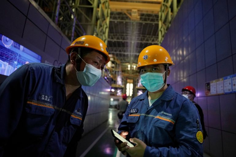 Employees stand at a cold rolling plant during a government-organised media tour to Baoshan Iron And Steel Co Ltd in Shanghai, China.