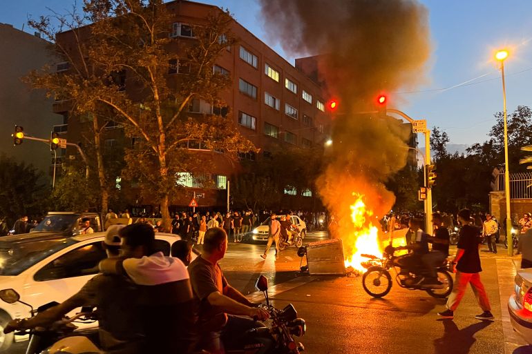 A motorcycle burns during a protest in Tehran over the death of Mahsa Amini