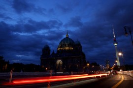 A television tower glows in Berlin next to the Berlin Cathedral with lighting reduced to save energy [File: Lisi Niesner/Reuters]