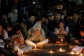People pray and lower their heads at a vigil for those who died in the Malang stadium disaster.