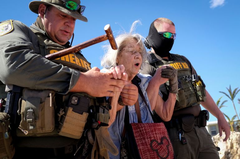 Sheriff officers help evacuate an older woman after Hurricane Ian devastated communities in Florida.