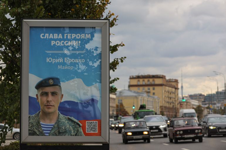 Cars drive near a board with an image of Russian service member Yury Brovko with a slogan reading "Glory to the Heroes of Russia" in Moscow, Russia October 4, 2022. REUTERS/Evgenia Novozhenina