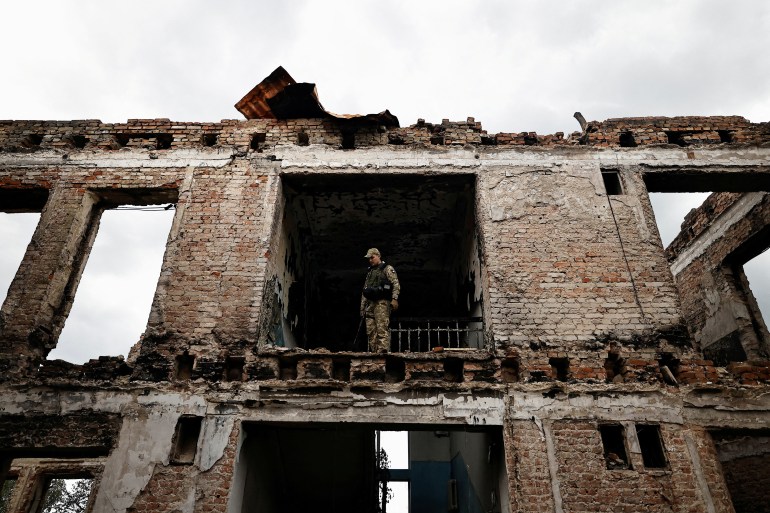 Illia Yerlash, a Ukrainian army officer, stands among the remains of a school that was destroyed during the fighting between Russian troops and the Ukrainian army, amid Russia's invasion of Ukraine, in the recently liberated town of Lyman, Donetsk region, Ukraine, October 5, 2022