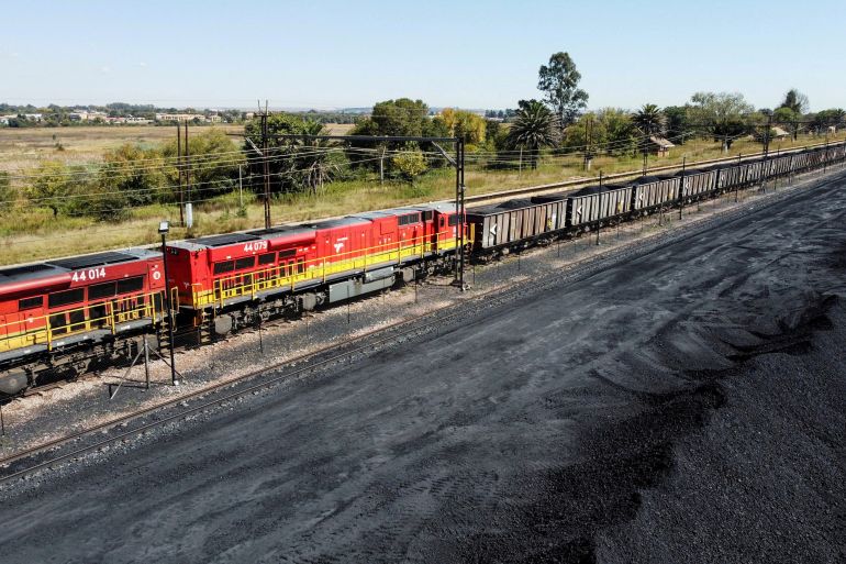 FILE PHOTO: A Transnet Freight Rail train is seen next to tons of coal mined from the nearby Khanye Colliery mine, at the Bronkhorstspruit station, in Bronkhorstspruit, around 90 kilometres north-east of Johannesburg, South Africa, April 26, 2022. REUTERS/Siphiwe Sibeko/File Photo
