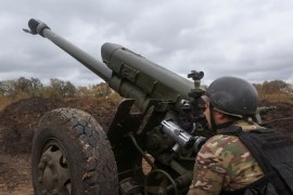 A member of the Ukrainian National Guard prepares a D-30 howitzer the in Kharkiv region [Vyacheslav Madiyevskyy/Reuters]