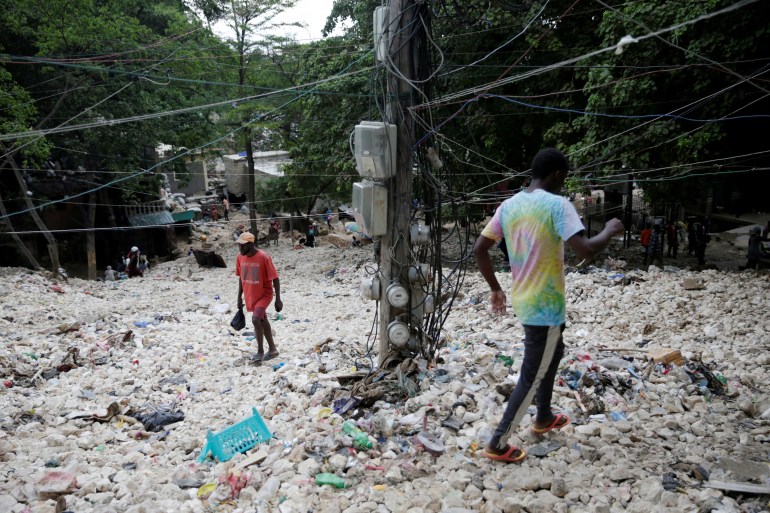 People walk along an area affected by the passage of Tropical Storm Laura, in Port-au-Prince, Haiti August 25, 2020.