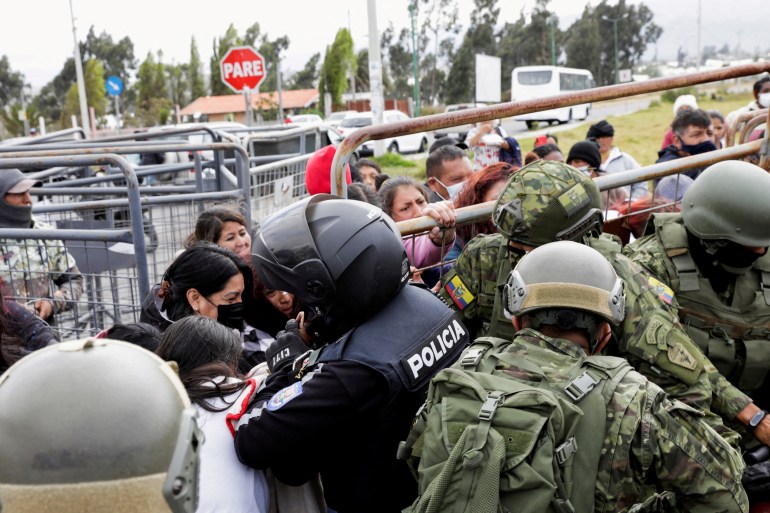 Relatives push fences outside an Ecuadorian prison