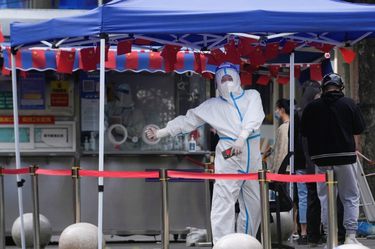 A worker in a protective suit following a COVID-19 outbreak in Shanghai, China, in October 2022 [File: Aly Song/Reuters]