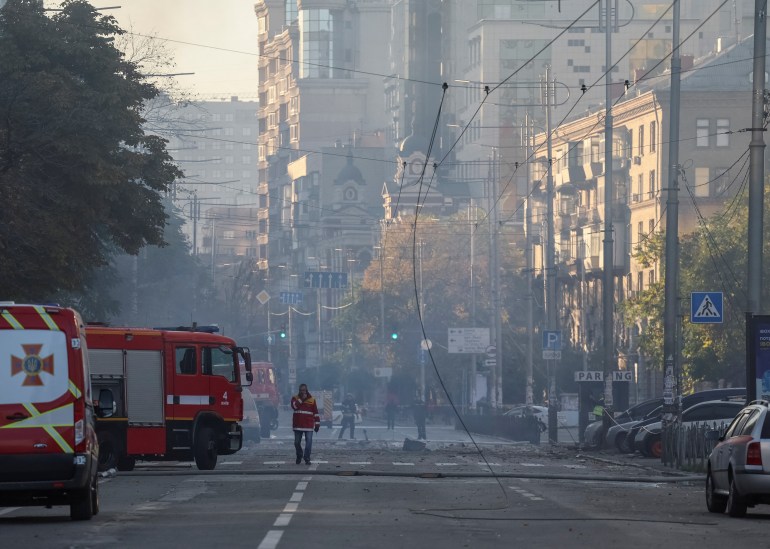 smoke in the street and firefighters at work after a drone strike on kyiv