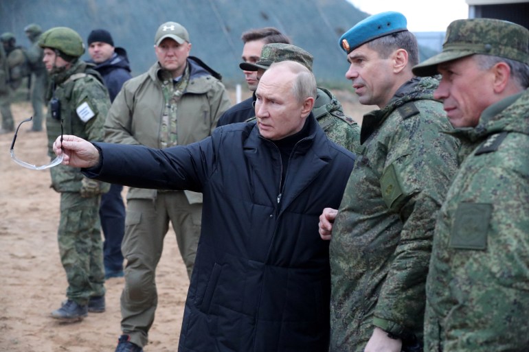 Russian President Vladimir Putin talks to a deputy commander while other military personnel looks on at a training centre in Ryazan Region, Russia.