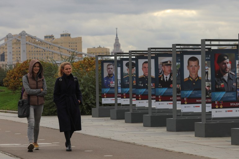 Women walk past banners honouring Russian service members involved in Russia-Ukraine conflict, on embankment in Moscow, Russia October 20, 2022. REUTERS/Evgenia Novozhenina