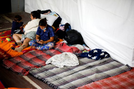 Venezuelan migrants sit on a bed