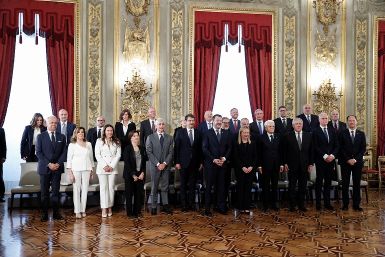 Italian President Sergio Mattarella and Prime Minister Giorgia Meloni stand with new government cabinet ministers during the swearing-in ceremony, at the Quirinale Presidential Palace in Rome, Italy