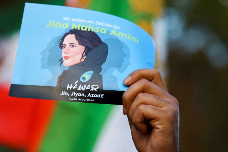 A demonstrator holds a poster during a protest following the death of Mahsa Amini in Iran, in Berlin, Germany, October, 22, 2022.