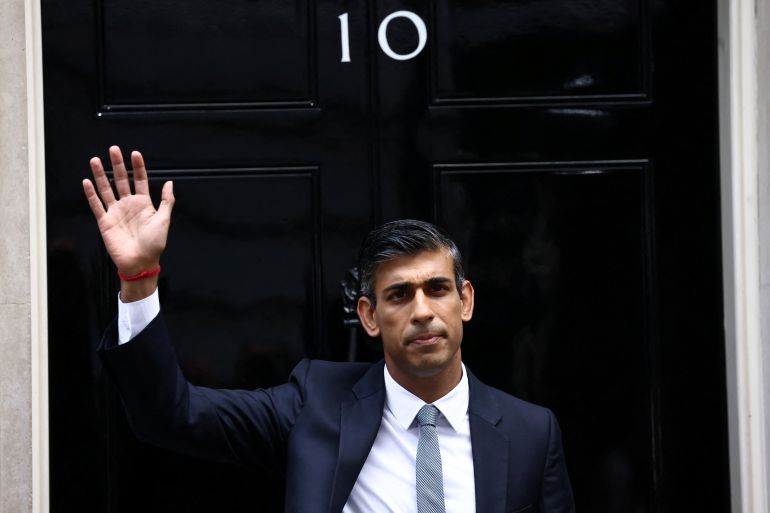 Britain's new Prime Minister Rishi Sunak waves as he enters Number 10 Downing Street.