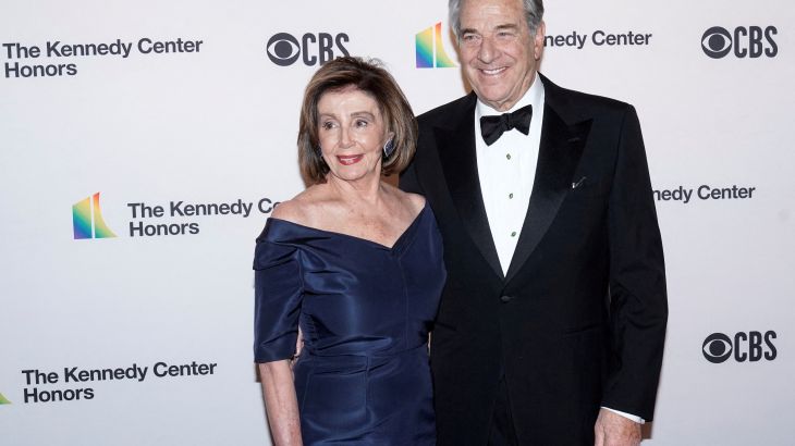 Nancy (in blue dress) and Paul (in black tux) Pelosi with arms around each other posing for photo