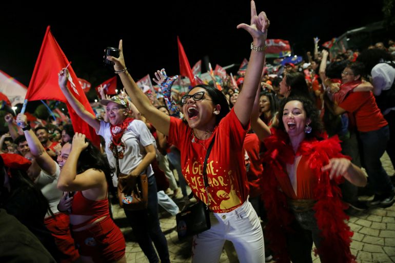 Lula supporters in red shorts and with flags celebrate his victory in Brasilia, Brazil.