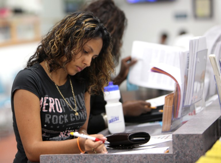 Janessa Rivera fills out a form for unemployment benefits during her second visit to the California Employment Development Department office in Sacramento, Calif. 