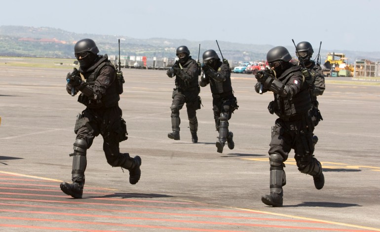 Indonesia's kopassus unit in black combat uniforms run across the tarmac at Bali airport during a training session with Australia's SAS