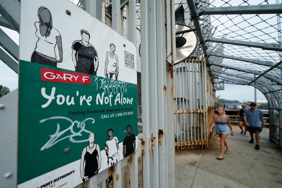 A sign for a suicide prevention hotline is displayed on the pedestrian walkway of the George Washington Bridge in New York