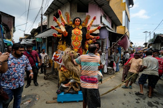 Laborers pull a clay idol of Hindu goddess Durga to load on a truck ahead of Durga Puja festival at Kumortuli