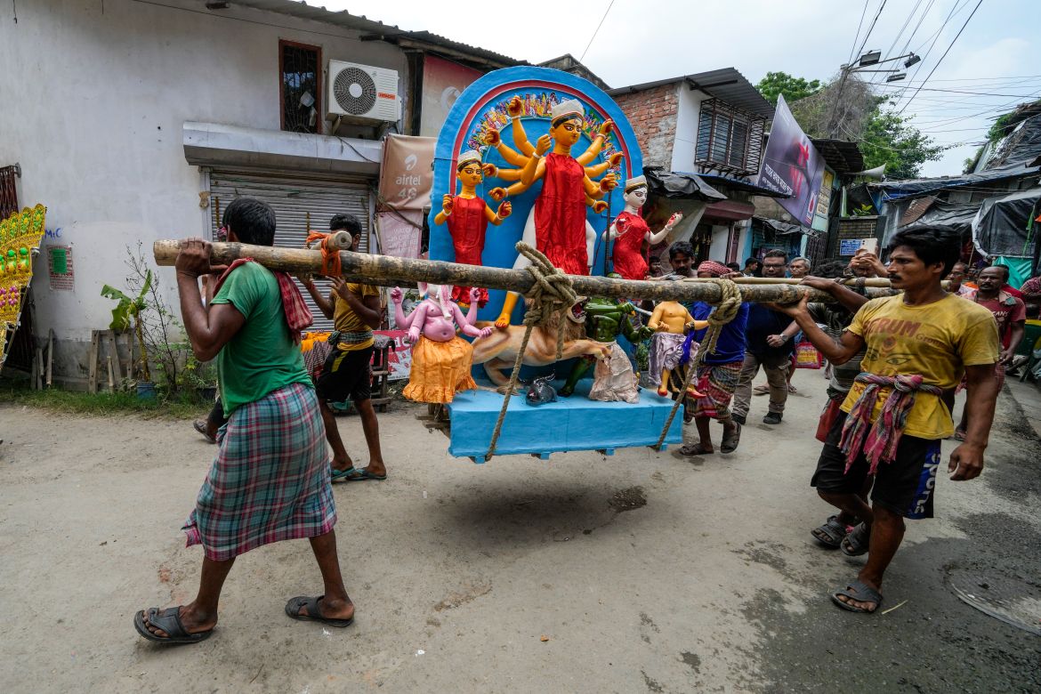 Laborers carry an idol of Hindu goddess Durga towards a worship place ahead of Durga Puja festival at Kumortuli, the potters' place, in Kolkata