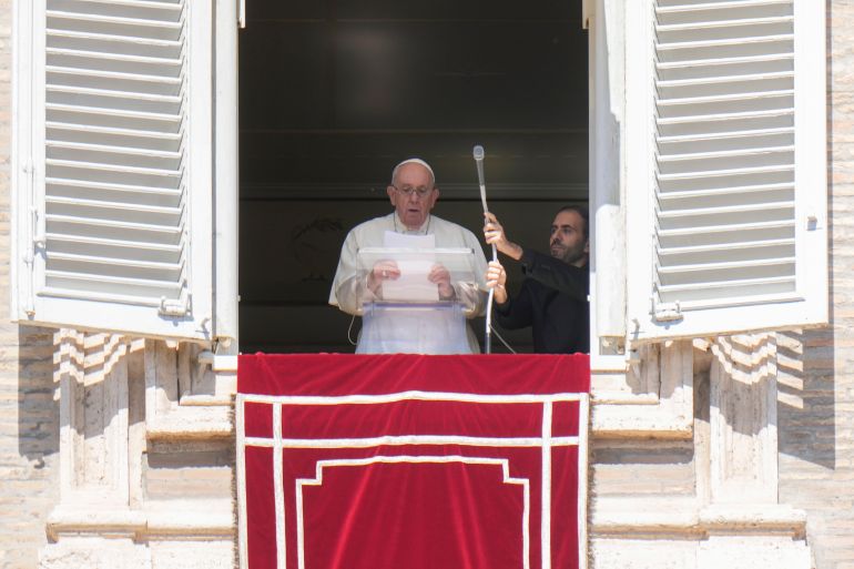 Pope Francis reads a message during the Angelus noon prayer from the window of his studio overlooking St.Peter's Square