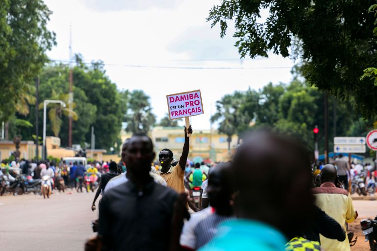Supporters of Capt. Ibrahim Traore cheer in the streets of Ouagadougou, Burkina Faso, Sunday, Oct. 2, 2022. Burkina Faso's new junta leadership is calling for calm after the French Embassy and other buildings were attacked. (AP Photo/Kilaye Bationo)
