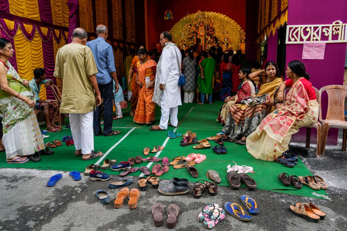 Devotees leave their sandals outside in reverence as they arrive to offer prayer to Hindu goddess Durga inside a makeshift worship place on the second