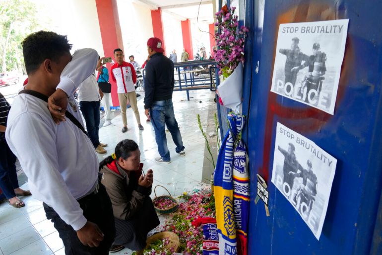 A man breaks down at a memorial for the victims of Saturday's soccer match stampede in front of gate 13 at the Kanjuruhan Stadium in Malang, Indonesia on Oct 4, 2022 [Achmad Ibrahim/AP]