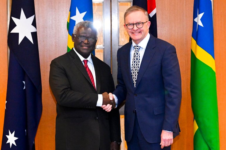 Australian Prime Minister Anthony Albanese (right) and Solomon Islands Prime Minister Manasseh Sogavare (left) shake hands ahead of a bilateral meeting at Parliament House in Canberra, Australia on October 6, 2022 [Lukas Coch/AAP via AP]