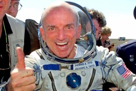 Dennis Tito in a space suit gives a thumbs up after returning to earth from Space in 2001