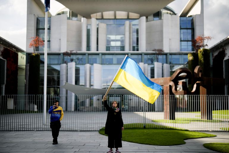 A woman waves a Ukrainian flag as she attends a protest against the war in Ukraine in front of the chancellery in Berlin, Germany, October 11, 2022