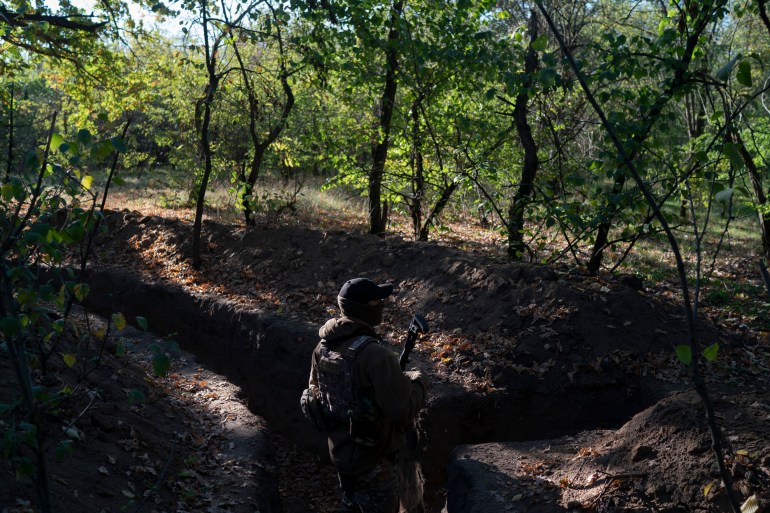 A Ukrainian serviceman checks the trenches dug by Russian soldiers in a retaken area in Kherson region.