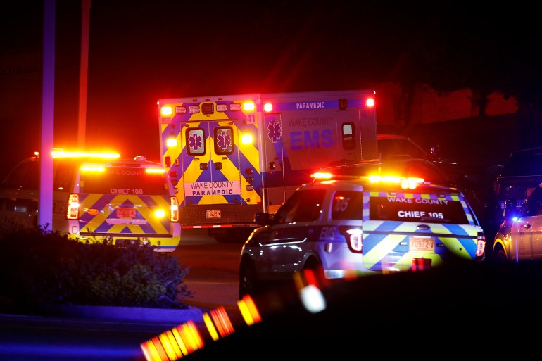 An ambulance believed to be carrying a shooting suspect arrives at Wake Medical Center Emergeny Room in Raleigh, N.C., Thursday, Oct. 13, 2022 surrounded by police