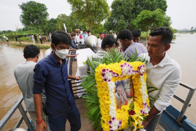 A portrait of boat accident victim Chanda July is carried by her relative during a funeral procession in Cambodia on October 14, 2022 [Heng Sinith/AP]