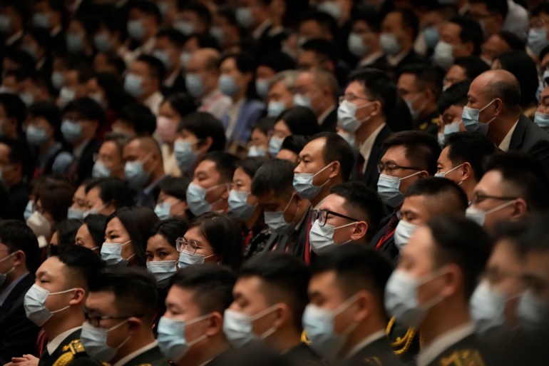 Delegates to the 20th Party Congress wear masks while sitting in the Great Hall of the People