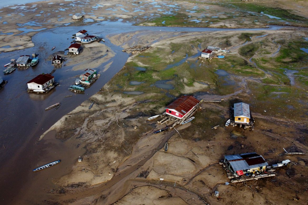 Houseboats sit amid drought-impacted land near the Solimões River, in Tefe, Amazonas state, Brazil
