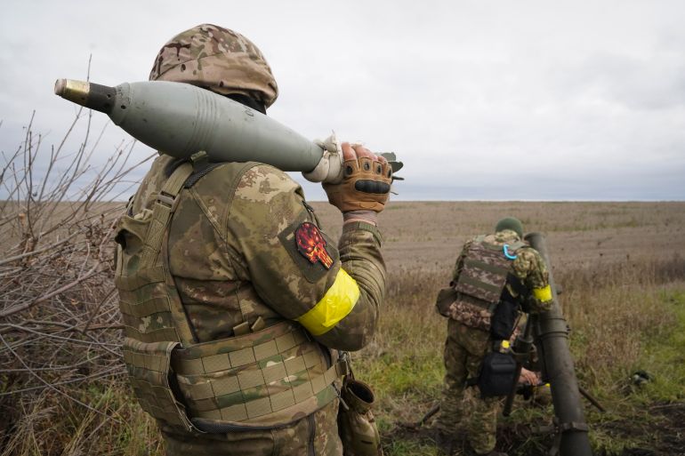 Ukrainian National guard soldiers prepare to fire at Russian positions with a mortar near Kharkiv, Ukraine, Tuesday, Oct. 25, 2022