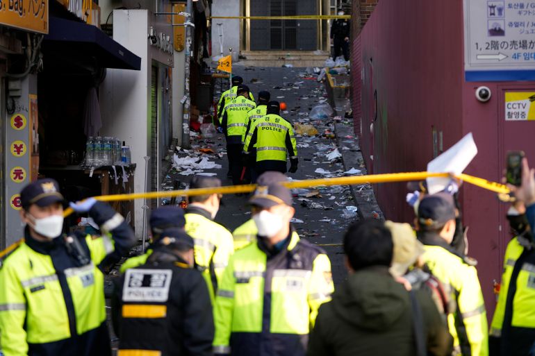 Police officers work at the scene of a fatal crowd surge in Seoul, South Korea.