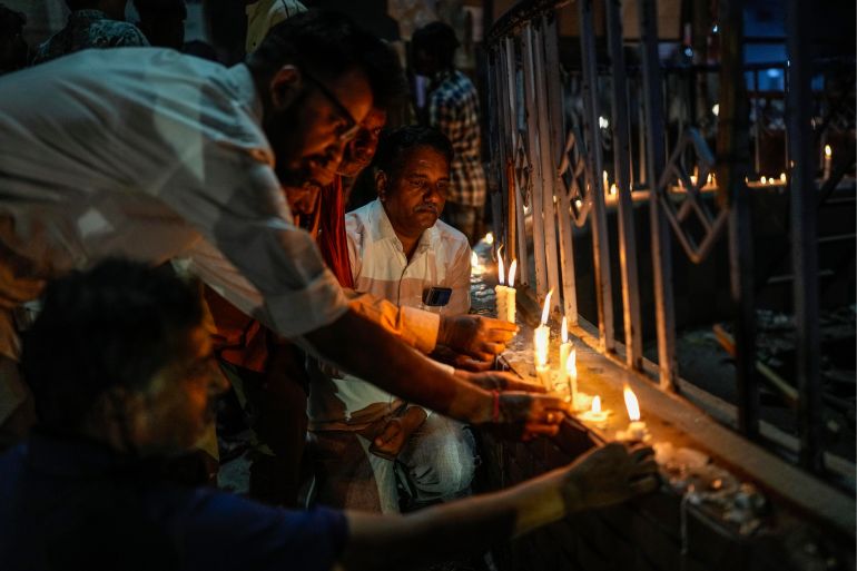 People light candles to pay tribute to victims of Sunday's bridge collapse in Morbi town, in the western Indian state of Gujarat, Monday, Oct. 31, 2022. Military teams were searching Monday for people missing after a 143-year-old suspension bridge collapsed into a river Sunday in the western Indian state of Gujarat, sending hundreds plunging into the water and killing at least 133 in one of the country's worst accidents in years. (AP Photo/Rafiq Maqbool)