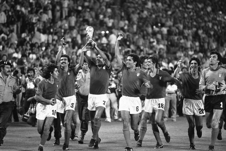 Italy's Gaetano Scirea No 7, holds onto the World Cup, as members of the team run around the pitch, at the end of the Football World Cup Final against West Germany in Santiago Bernabau Stadium, Madrid