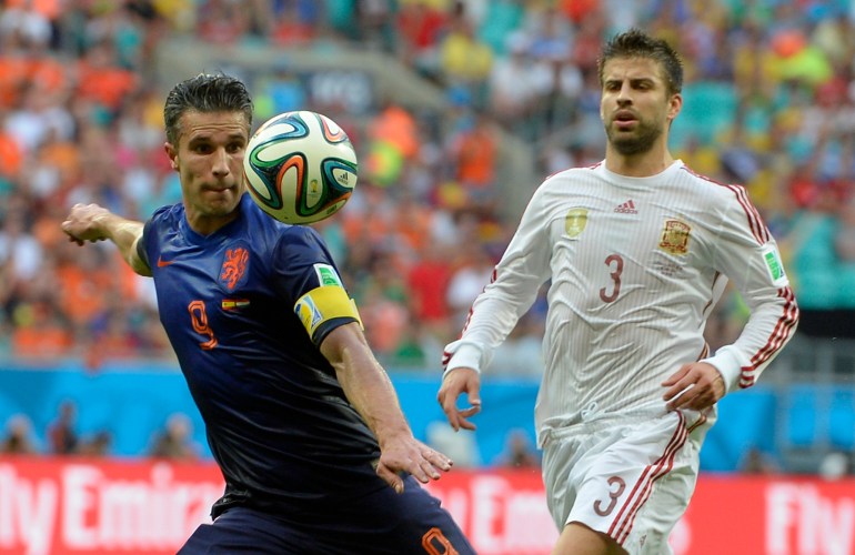 Netherlands' Robin van Persie, left, prepares to take a shot watched by Spain's Gerard Pique during the group B World Cup soccer match