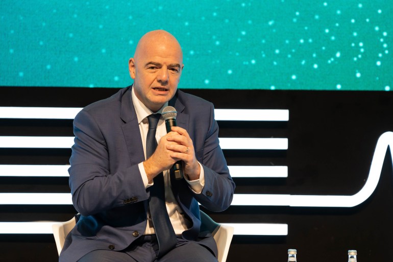 Gianni Infantino, FIFA president, speaking at the World Innovation Summit for Health 2022 in Doha, holding microphone, wearing suit