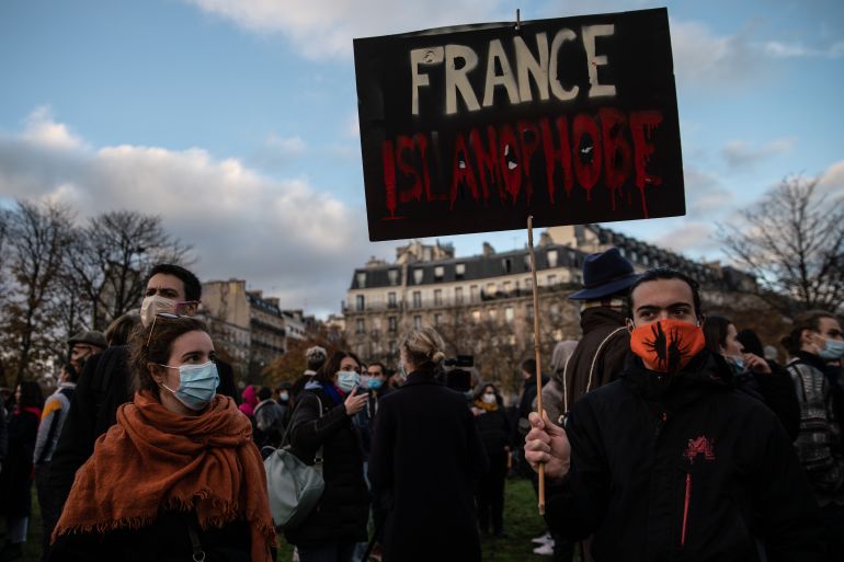 A protestor holds a placard that reads 'France Islamophobe'