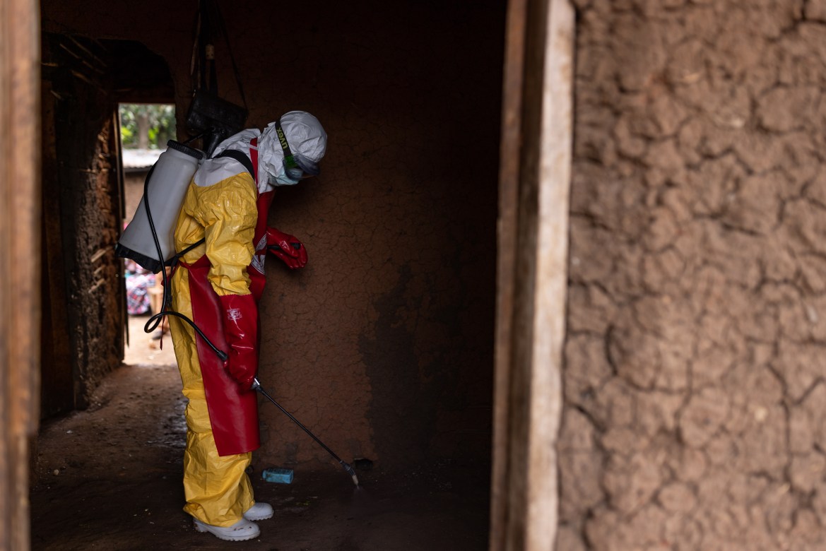 Red Cross workers sanitize a house after burying a 3-year-old boy suspected of dying from Ebola