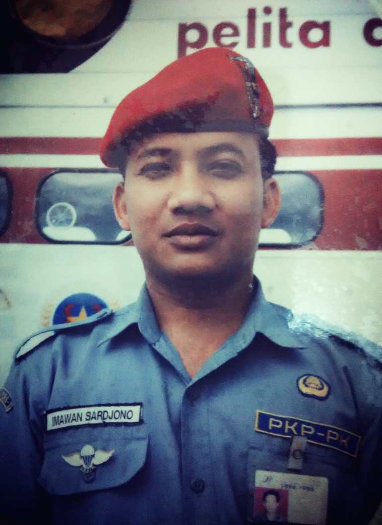 A portrait of Imawan Sardjono in his uniform with a red beret and blue shirt