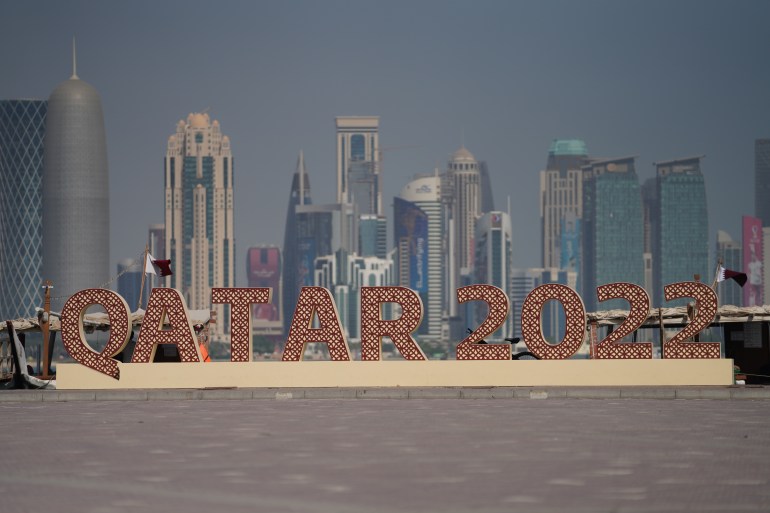 A Qatar 2022 logo in front of the skyline of the West Bay in Doha, Qatar.